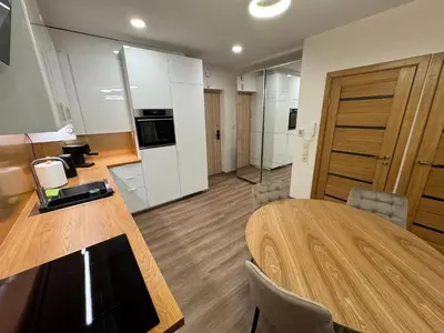 a conference room with a wooden table and a kitchen at Lovely Flat with Great Central Location Kaunas in Kaunas