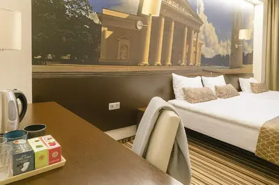 a hotel room with a bed and a table at Vilnius City Room in Vilnius