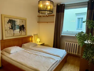 a bedroom with a bed and a large window at Pilies23 Old Town Luxury Apartment in Vilnius