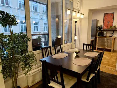 a dining room with a table and chairs and a window at Pilies23 Old Town Luxury Apartment in Vilnius