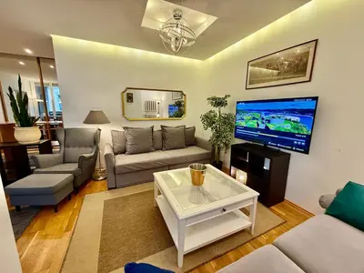 a living room with a couch and a flat screen tv at Pilies23 Old Town Luxury Apartment in Vilnius