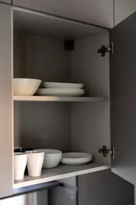 a cabinet with white bowls and plates in it at Vilnius City Center Deluxe Apartment in Vilnius