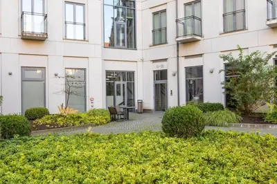 a large white building with windows and bushes at Vilnius City Center Deluxe Apartment in Vilnius