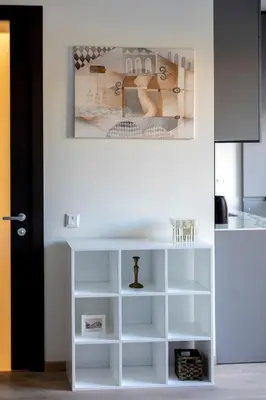a white shelf in a kitchen with a picture on the wall at Vilnius City Center Deluxe Apartment in Vilnius