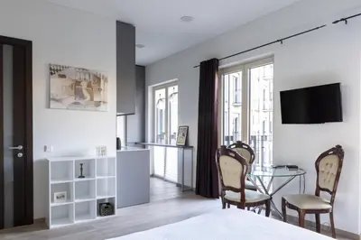 a bedroom with a table and chairs and a tv at Vilnius City Center Deluxe Apartment in Vilnius