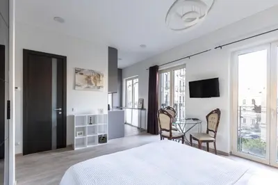 a bedroom with a bed and a table and chairs at Vilnius City Center Deluxe Apartment in Vilnius