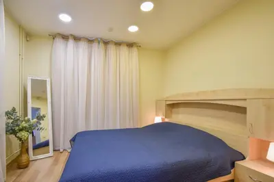 a bedroom with a large blue bed and a window at A cozy apartment with private entrance in the city centre in Panevėžys