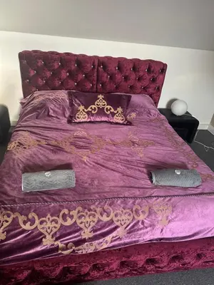 a purple bed with a purple comforter and pillows at B&M Jeccuzi Studio self-check in in Vilnius