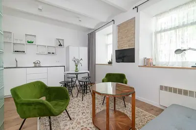 a living room with green chairs and a table at Gate of Dawn Old town in Vilnius