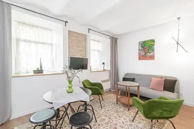 a living room with a couch and a table and chairs at Gate of Dawn Old town in Vilnius