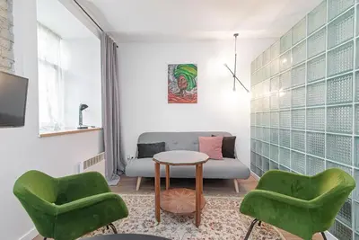 a living room with two green chairs and a couch at Gate of Dawn Old town in Vilnius