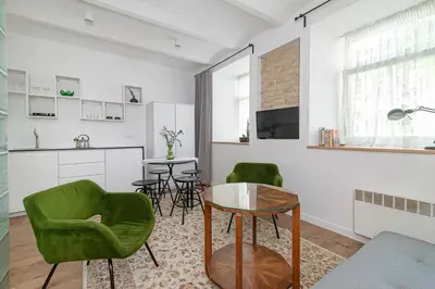 a living room with green chairs and a table at Gate of Dawn Old town in Vilnius