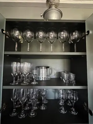a bunch of wine glasses on a shelf at Piliakalnio Apartmentai in Kupiškis