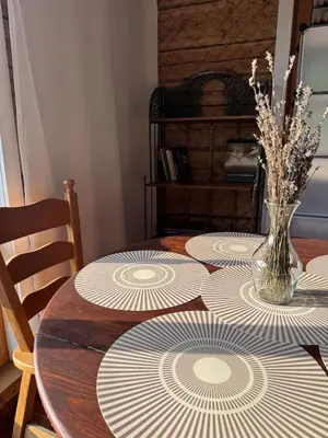 a table with plates on it with a vase on it at Piliakalnio Apartmentai in Kupiškis