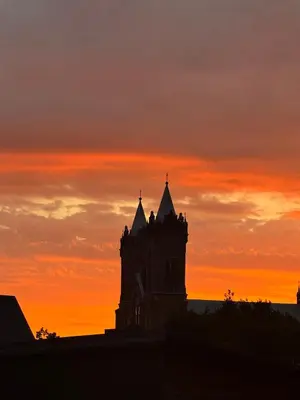 a silhouette of a building with a sunset in the background at Piliakalnio Apartmentai in Kupiškis