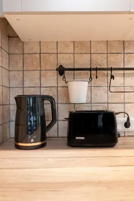 a black toaster sitting on a counter next to a microwave at Cozy Urban Apartment in Vilnius