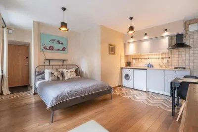 a bedroom with a bed and a kitchen at Cozy Urban Apartment in Vilnius