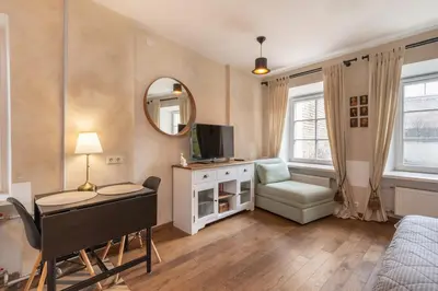 a bedroom with a desk and a bed and a mirror at Cozy Urban Apartment in Vilnius