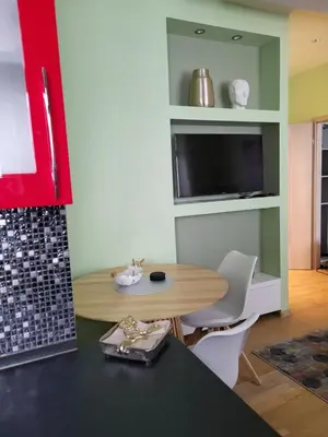 a dining room with a table and a tv at Siauliai Apartments - Traku in Šiauliai