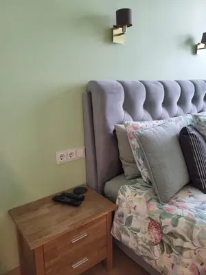 a couch sitting next to a wooden table next to a bed at Siauliai Apartments - Traku in Šiauliai