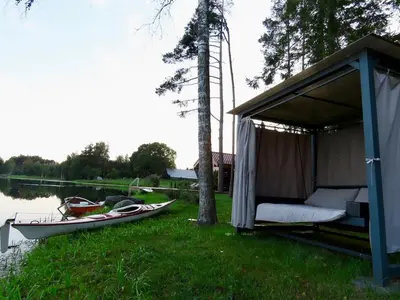 a gazebo with a bed and a boat in the grass at Lake terrace