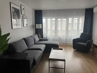 a living room with a couch and a chair at Studio Apartment with Balcony in Central Druskininkai in Druskininkai