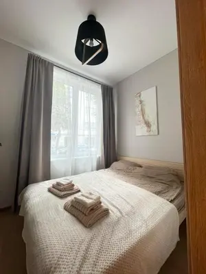 a bedroom with two towels on a bed with a window at Apartment 52 in Kaunas