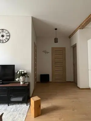 an empty living room with a clock on the wall at Apartment 52 in Kaunas