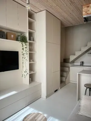 a living room with white cabinets and a tv at Designer studio in Vilnius