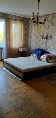 a large bed in a room with a wooden floor at Cozy room with balcony in Visaginas in Visaginas