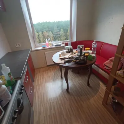 a small room with a table and a red couch at Cozy room with balcony in Visaginas in Visaginas