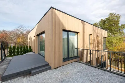 a house with glass doors and a balcony at Cottage Luxe Žaliakalnis in Kaunas