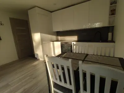 a kitchen with white cabinets and a table and chairs at Rasa in Marijampolė