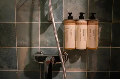 a group of three shampoo bottles on a wall at Pievos in Birštonas