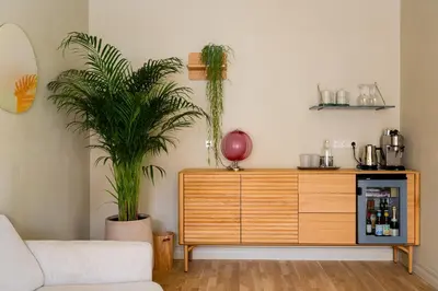 a living room with two potted plants and a dresser at Pievos in Birštonas