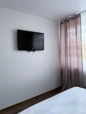 a bedroom with a flat screen tv on the wall at EVA apartment in Marijampolė