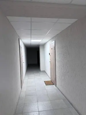 an empty hallway with two doors and a tile floor at EVA apartment in Marijampolė