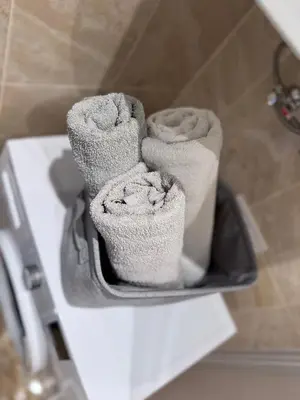 a pile of towels sitting on a shelf in a bathroom at EVA apartment in Marijampolė