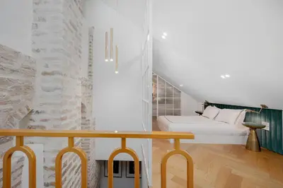 a white bedroom with a bed and a table at Luxury apartment in Old Town and Parking in Vilnius