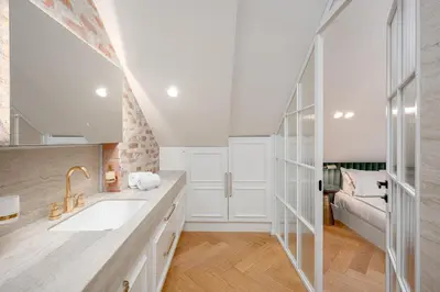 a white kitchen with a sink and a couch at Luxury apartment in Old Town and Parking in Vilnius