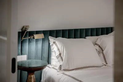 a bed with a green headboard and a table at Luxury apartment in Old Town and Parking in Vilnius