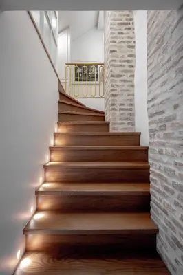 a staircase in a house with wooden floors and a brick wall at Luxury apartment in Old Town and Parking in Vilnius