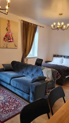 a living room with a blue couch and a bed at Old town studio in Kaunas