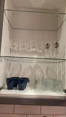 a shelf with wine glasses and bowls on it at Old town studio in Kaunas
