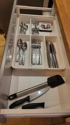a drawer filled with silver utensils on a table at Old town studio in Kaunas