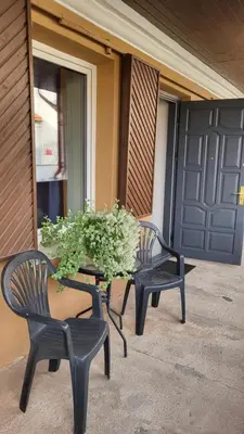 two chairs and a table with a potted plant on a porch at Old town studio in Kaunas