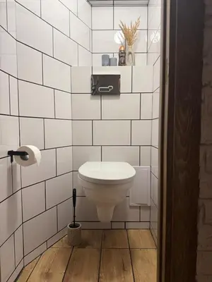 a white toilet in a bathroom with white tiles at Feels like home in Visaginas