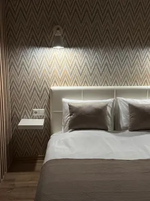 a bedroom with a white bed with a wall at Feels like home in Visaginas