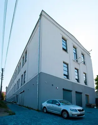 a car parked in front of a white building at Kaunas Design Loft in Kaunas