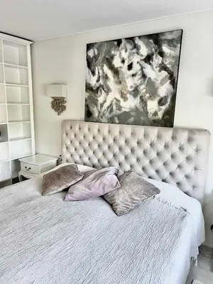 a bed with two pillows and a painting above it at Kaunas Design Loft in Kaunas